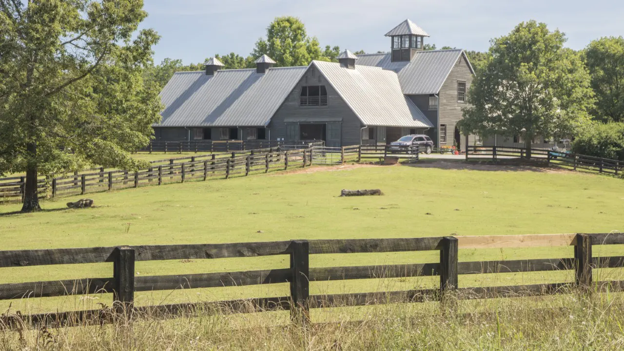 by TSW, Atlanta - Picture with a rural house in the background and a three-rail fence in the foreground, pasture land in-between