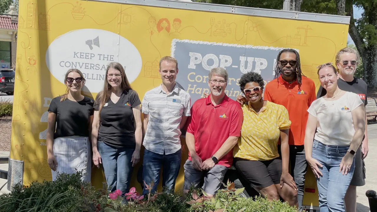 by TSW, Atlanta - The Planning Team standing Infront of a project banner after a long day of public input