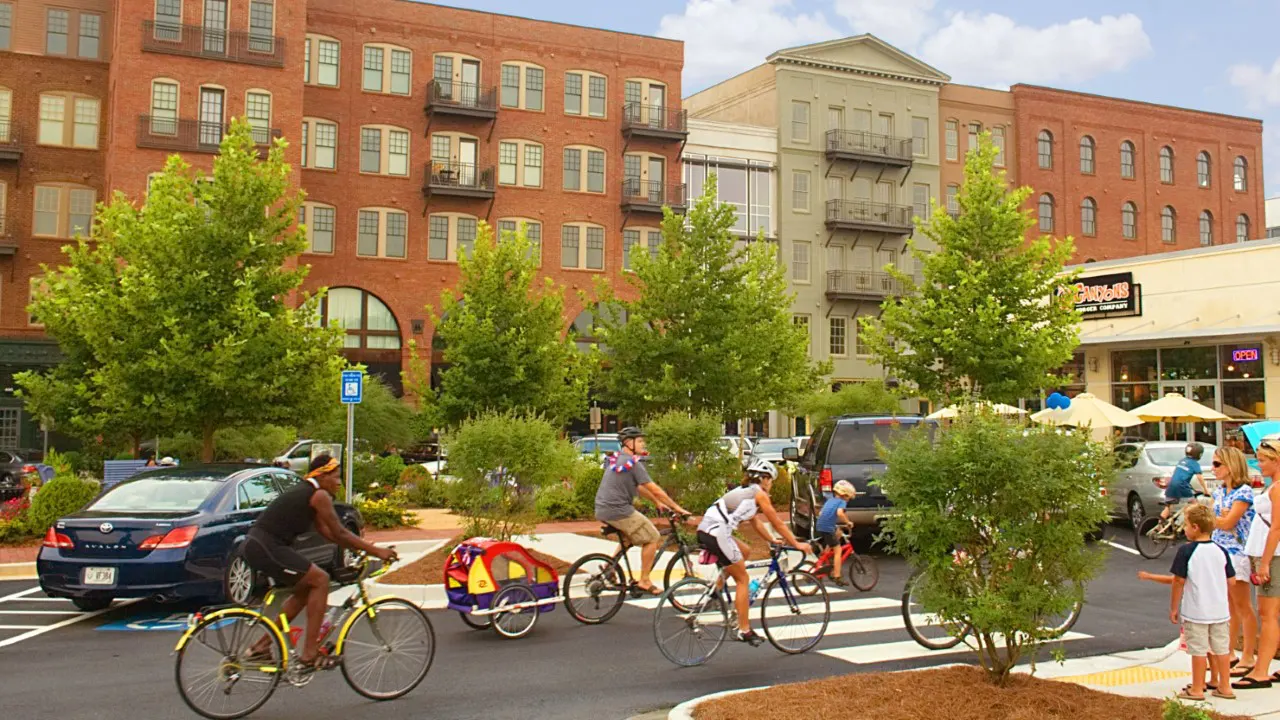 City of Woodstock Downtown Residential and Commercial Development by TSW. Cyclists traversing the parking lot